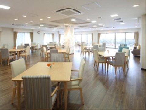 窓に囲まれた明るい雰囲気のダイニングルームである。大きなテーブルのダイニングセットが配置されているので、ゆったりと食事をとることができる。