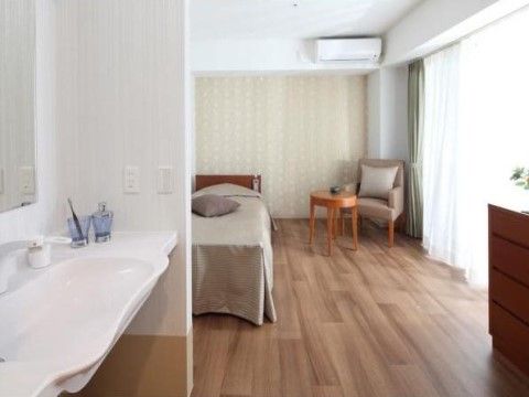 フローリングの床に、広く使いやすい洗面台がついている居室である。大きな掃き出し窓から入る光が、部屋を明るく照らしている。