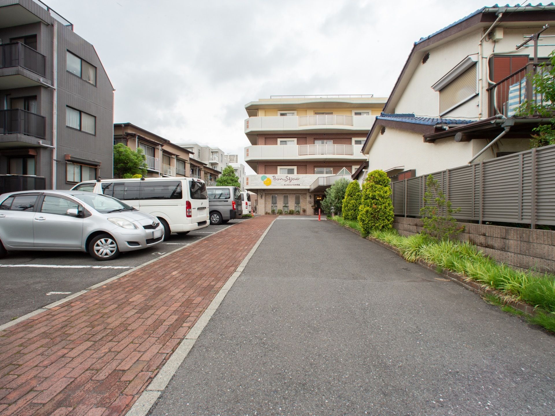 舗装された道とレンガが敷かれた道が真っ直ぐ伸びた駐車場