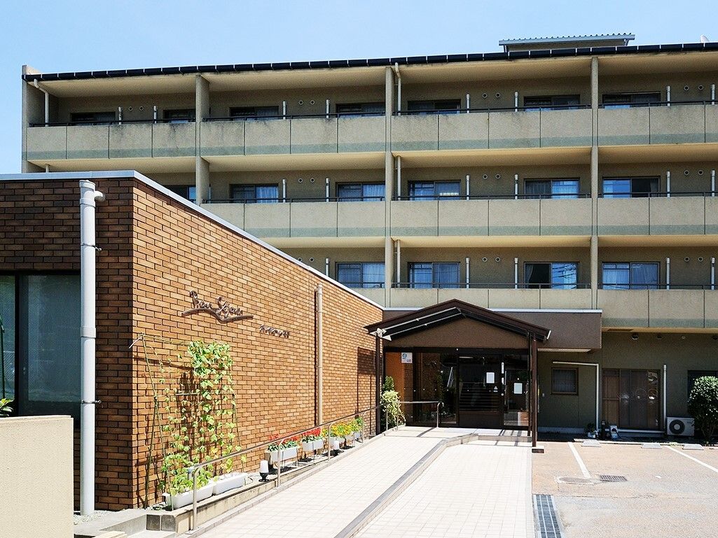 鉄筋コンクリート4階建ての建物で、入り口までは長いスロープになっている。建物の前は広く、駐車場になっている。