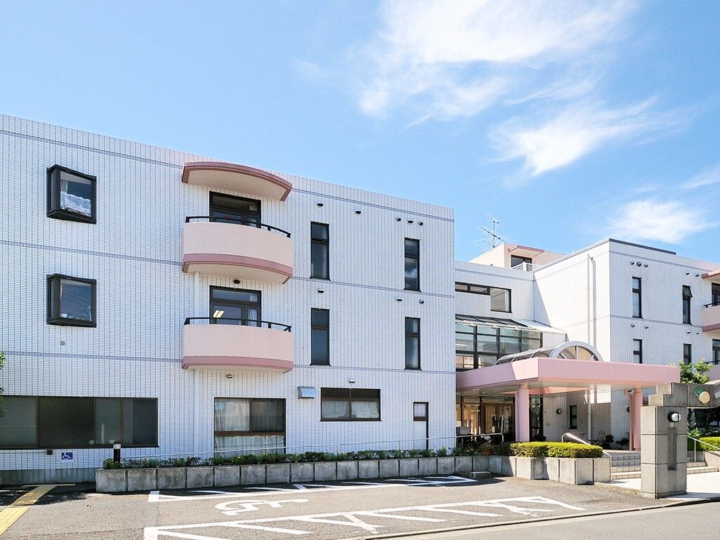 施設名が表示されたコンクリート製のゲートが中央にある玄関前