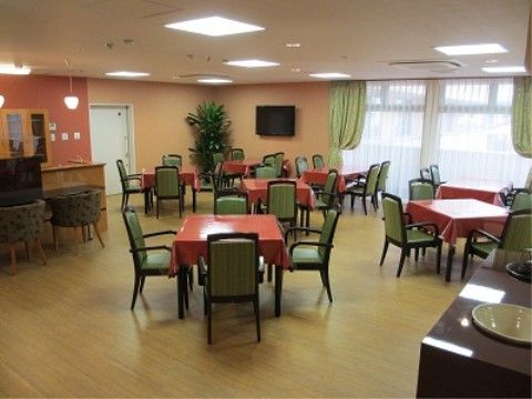 赤系統の色のテーブルクロスがかかったテーブルがある食堂