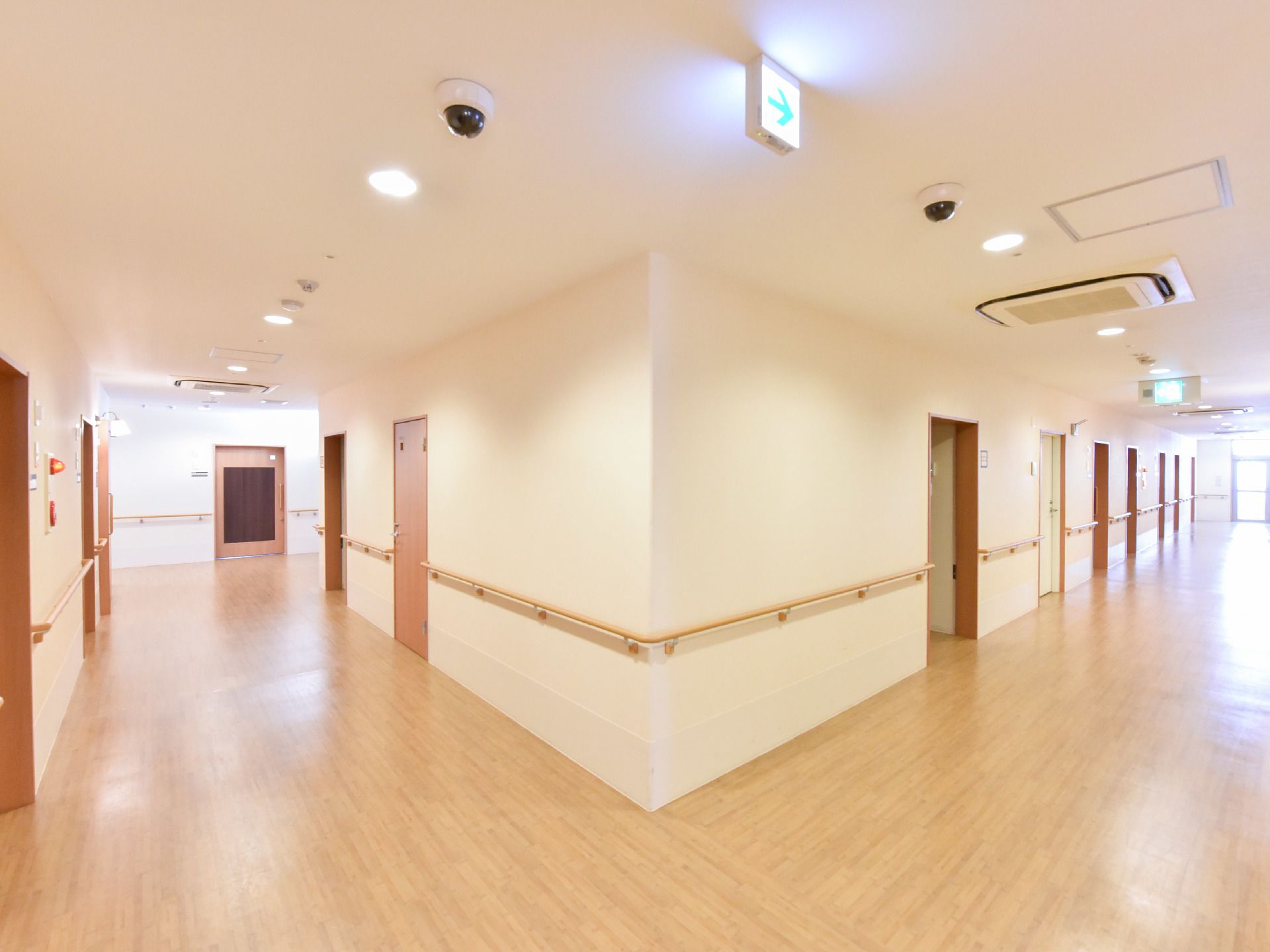 廊下の曲がり角は十分な広さがあるので車いす同士でも余裕ですれ違える。明るく障害なく見渡しやすい。照明と自然の光が入る。