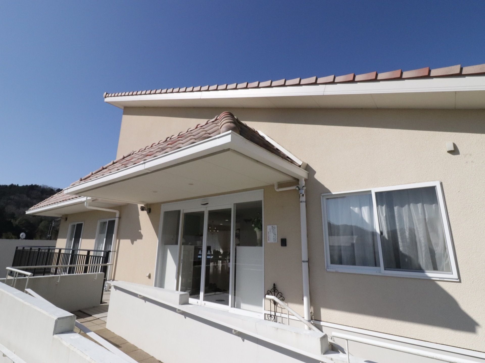 管理棟の外観。他の戸建ての居室とデザインや色が違い斜めの屋根がある。共有スペースとしての設備も入っている。