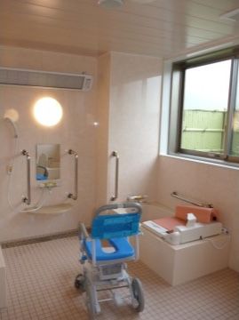 「ハートランド福山」の浴室。シャワーチェア、介助手すり、滑りにくい床を整え、入居者様の事故防止に貢献している。
