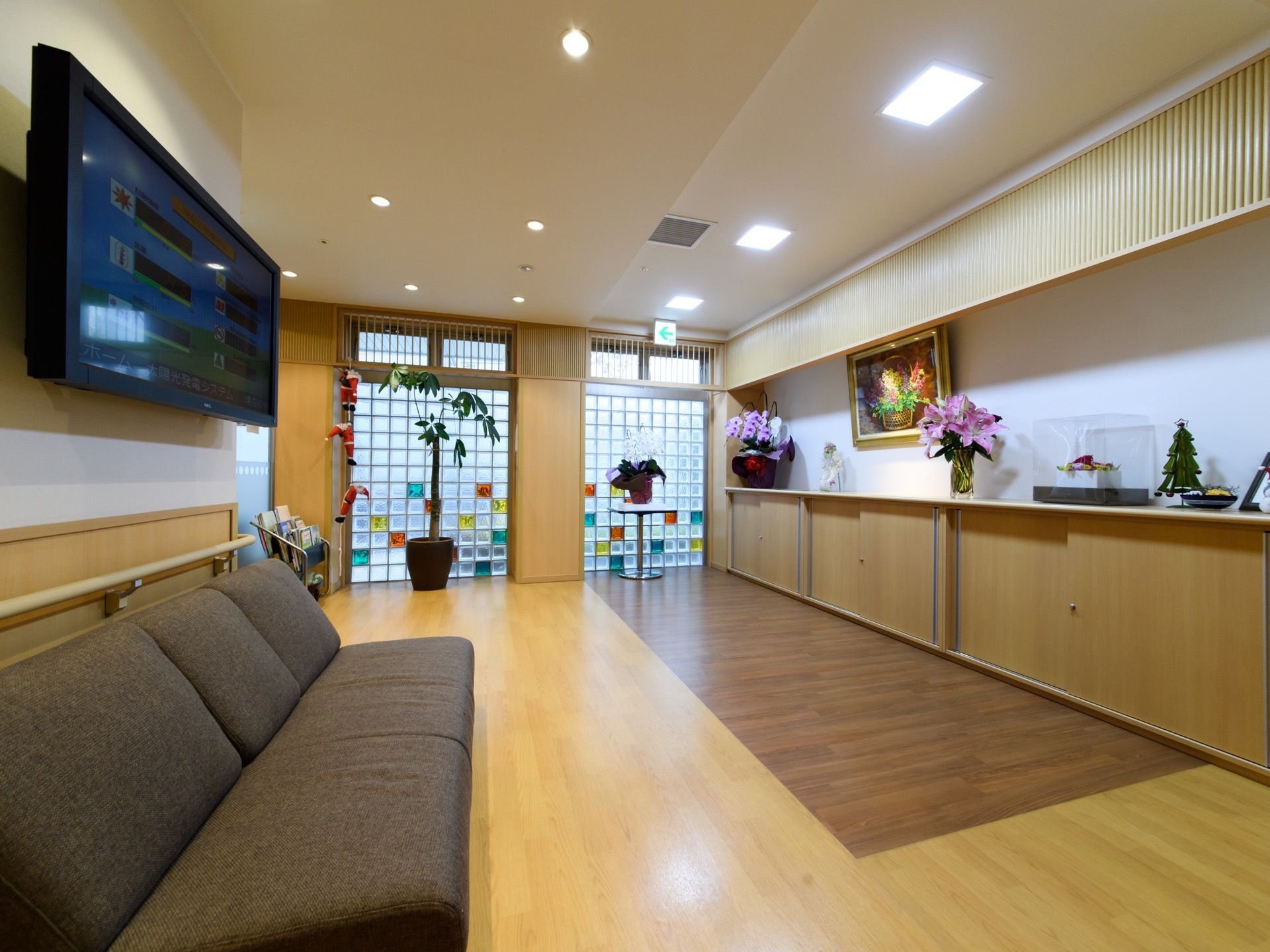 エントランスは広々した空間。観葉植物が置かれて明るく、ソファとテレビがあるので寛いで過ごすことができる。