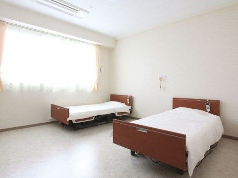 二台のベッドが置かれている、白い内装で明るくシンプルな部屋