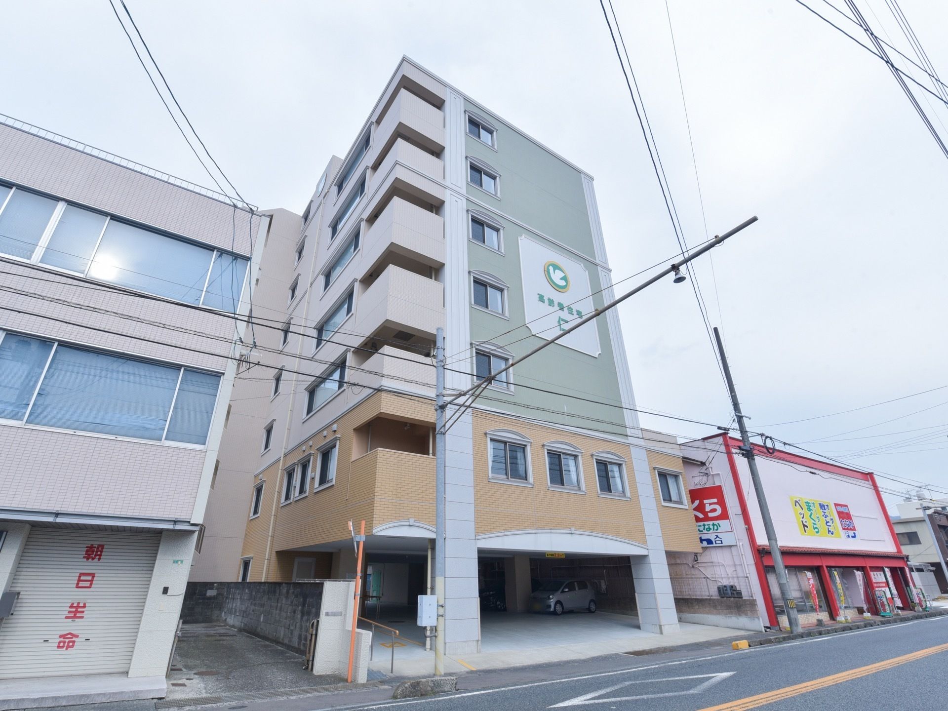 施設は道路に面して建てられている。7階建てである。1階部分は車の駐車スペースになっていて、数台の車を止められるようになっている。