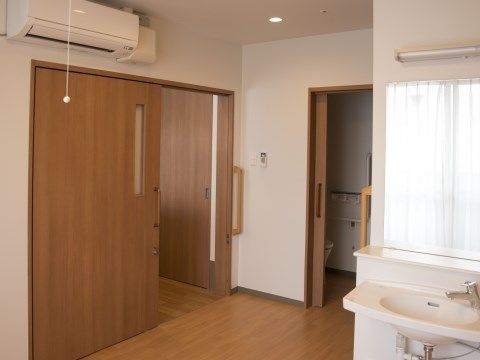 大きく開いているドアと、洗面スペース、トイレなどがある居室