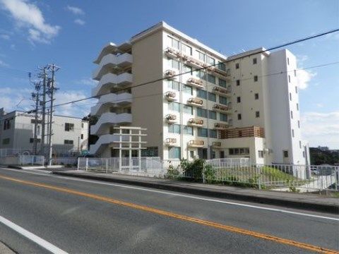 広い道路に面している、シンプルな外観の六階建ての建物