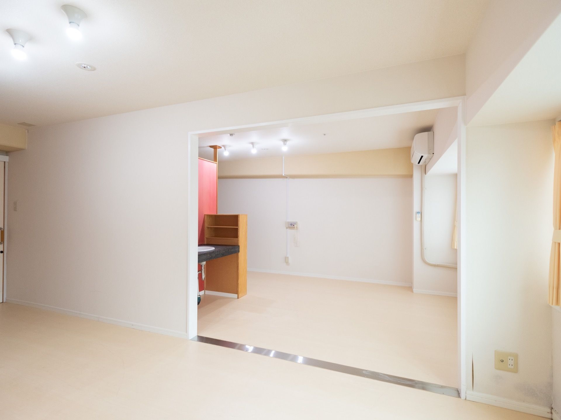 二間続きの居室がある。室内には、天井近くまであるパーティションや収納棚、洗面台やエアコンを設置。