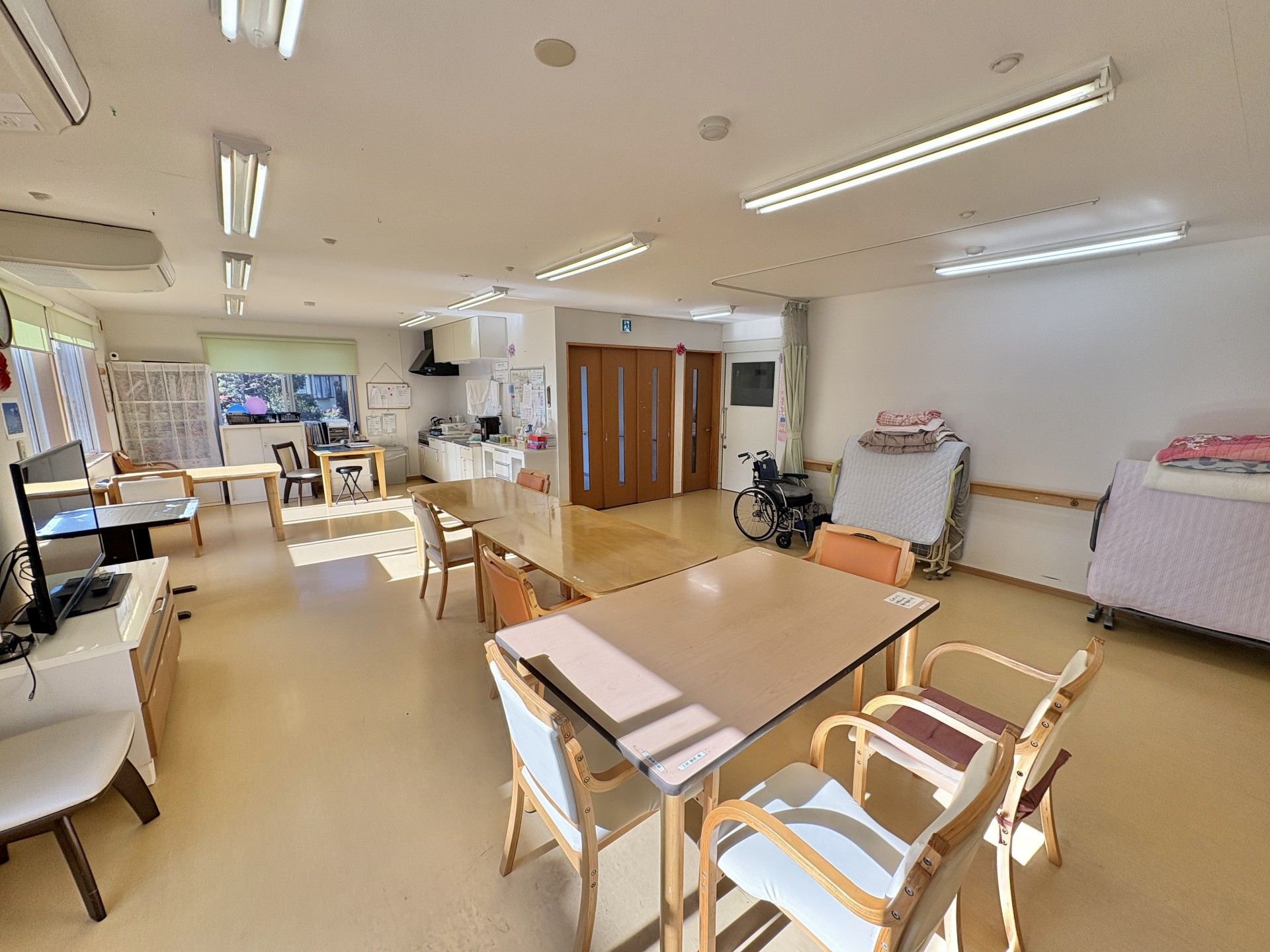 車椅子に乗って外出している高齢女性と介助をする女性ヘルパー