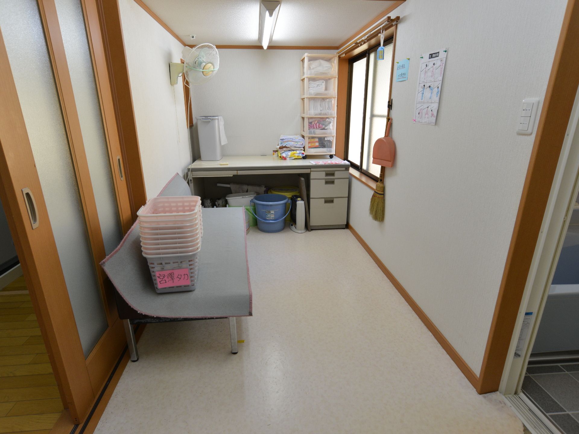お風呂の脱衣所には、それぞれ入居者様ごとのカゴを用意している。タオルも棚にまとめて置かれている。のぼせ対策に扇風機を設置している。