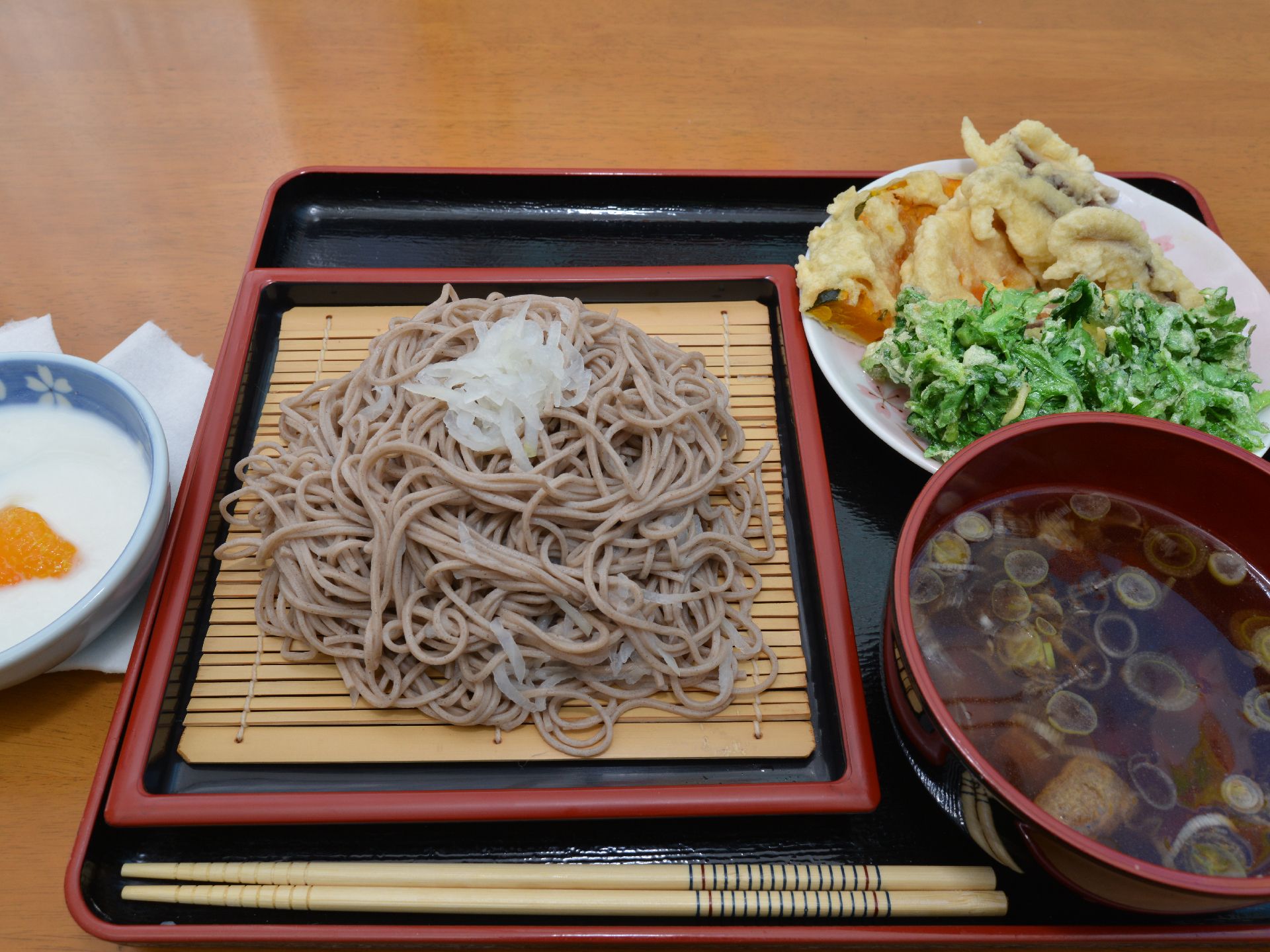 食事は和食。本日のメニューはざるそばで、季節の野菜を使った天ぷらがメイン。デザートも添えられ、栄養バランスが良い。