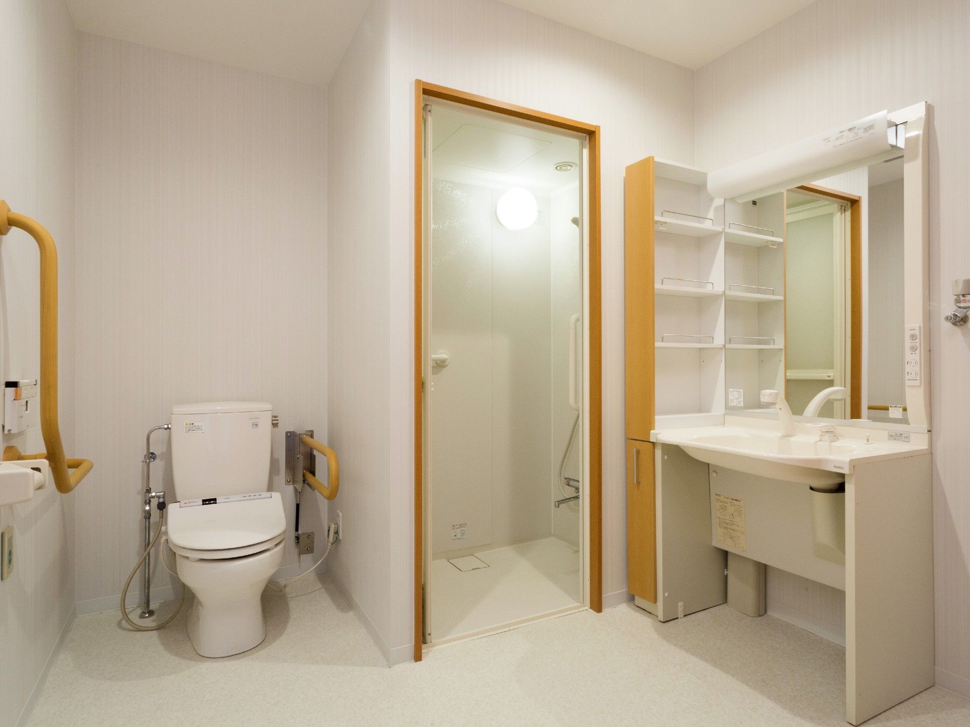 トイレは、壁に手すりがあり、安全性を配慮している。洗面台とシャワー室が同じスペースにあり、利便性の良いつくりとなっている。