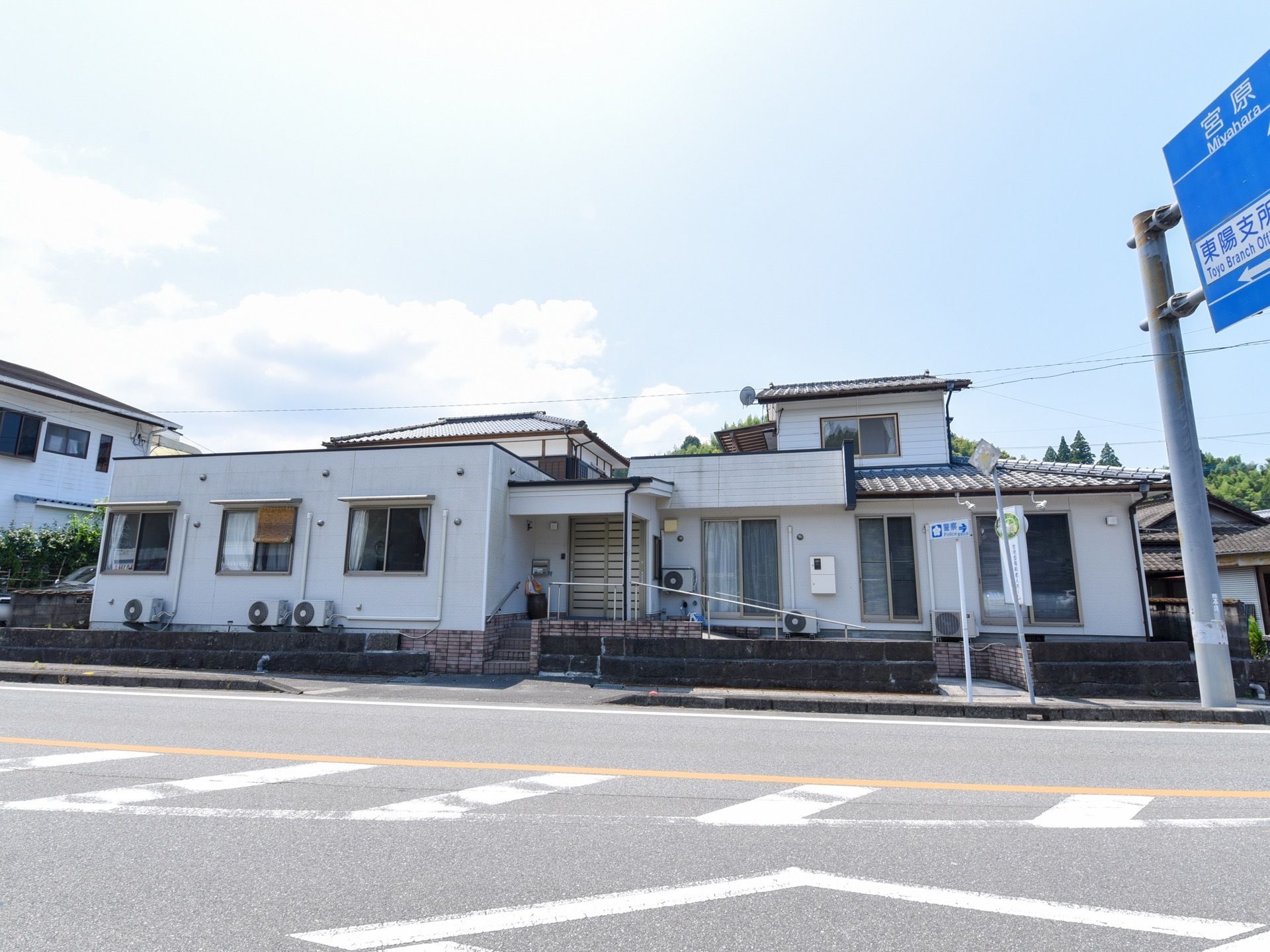 施設の外壁は白く明るい印象で、周辺にも馴染んでいる平屋建てである。玄関の前には小さな階段とスロープがある。