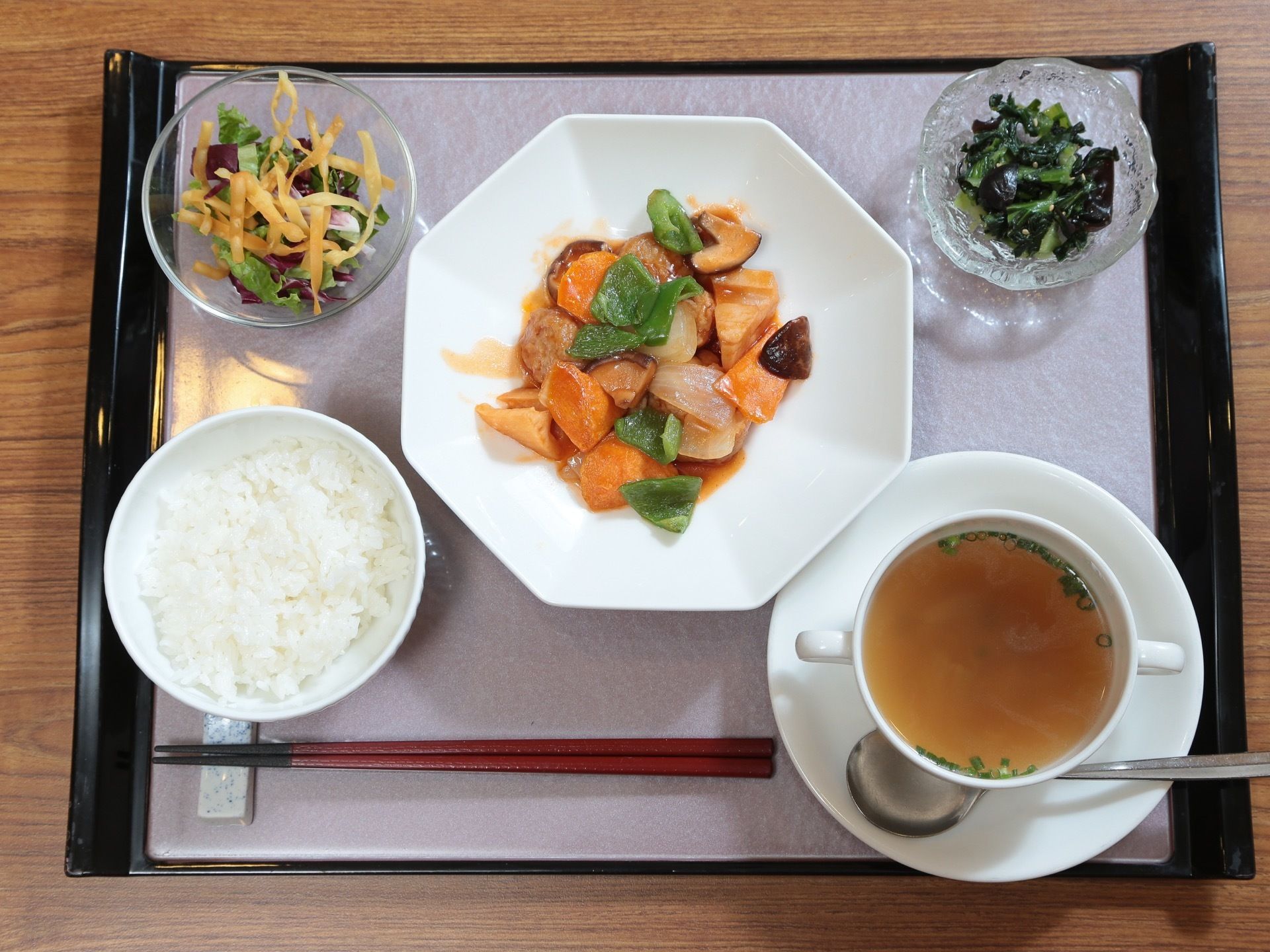 中央にメインの中華料理を置き、手前にご飯とスープがある。小鉢を２つとお箸置きにお箸をセットし、スープにはスプーンを添えている。