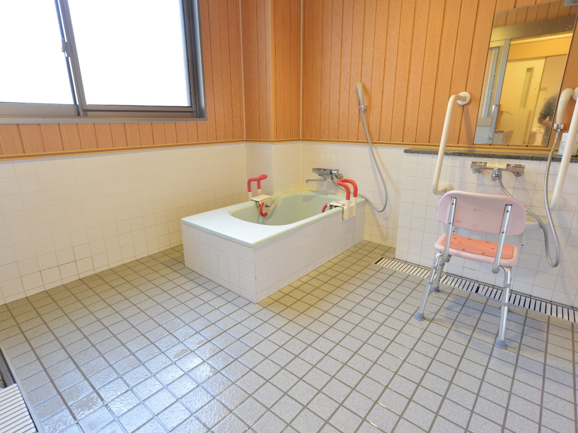 共用の家庭用お風呂がある。浴槽に手すりがついており、洗い場では背もたれ付きの椅子を利用することができる。