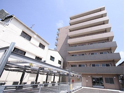 八階建てのマンション風の建物と、併設されている機械式の駐車場