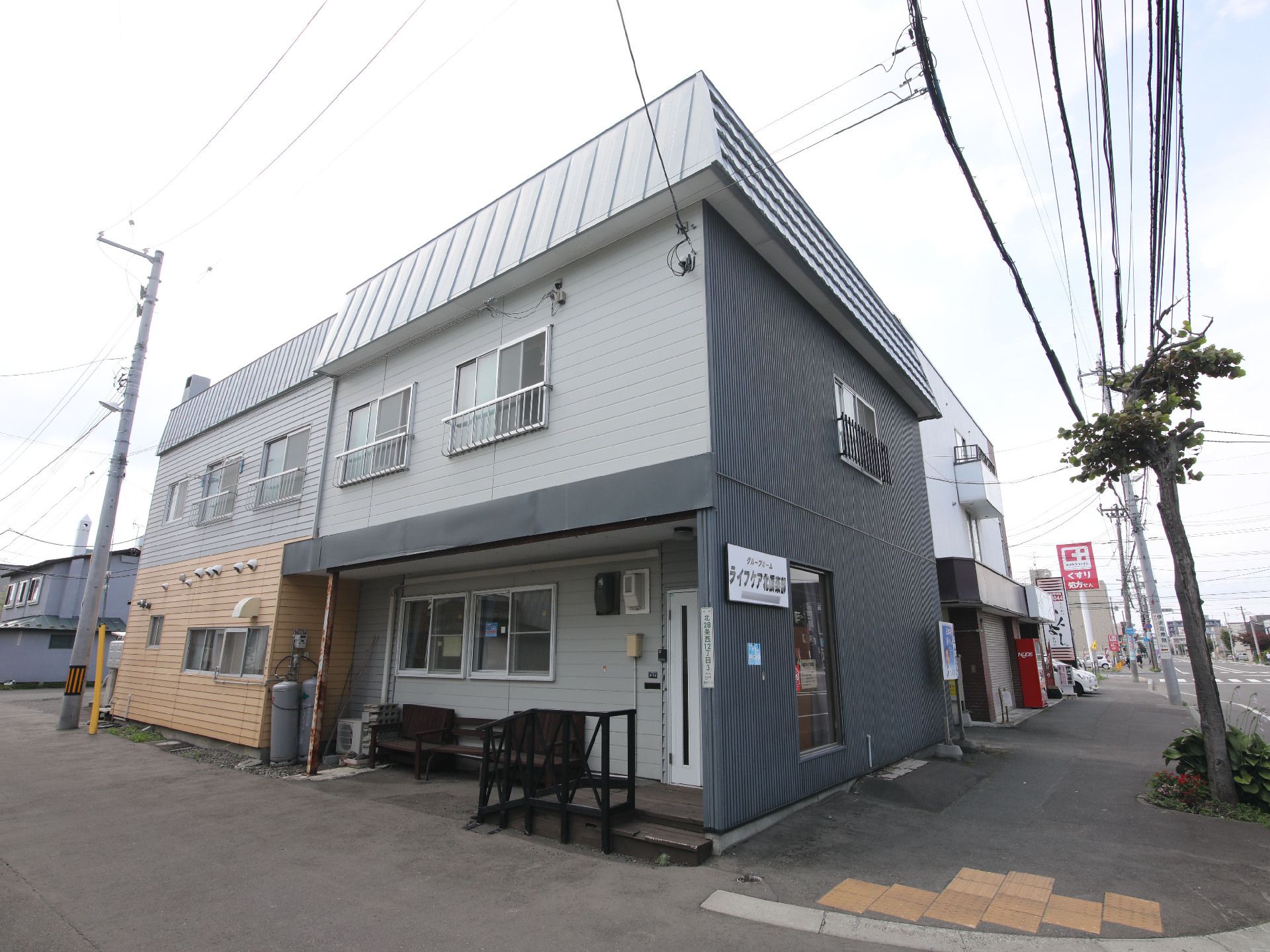 歩道沿いに立地している黒と白の外観の２階建ての建物