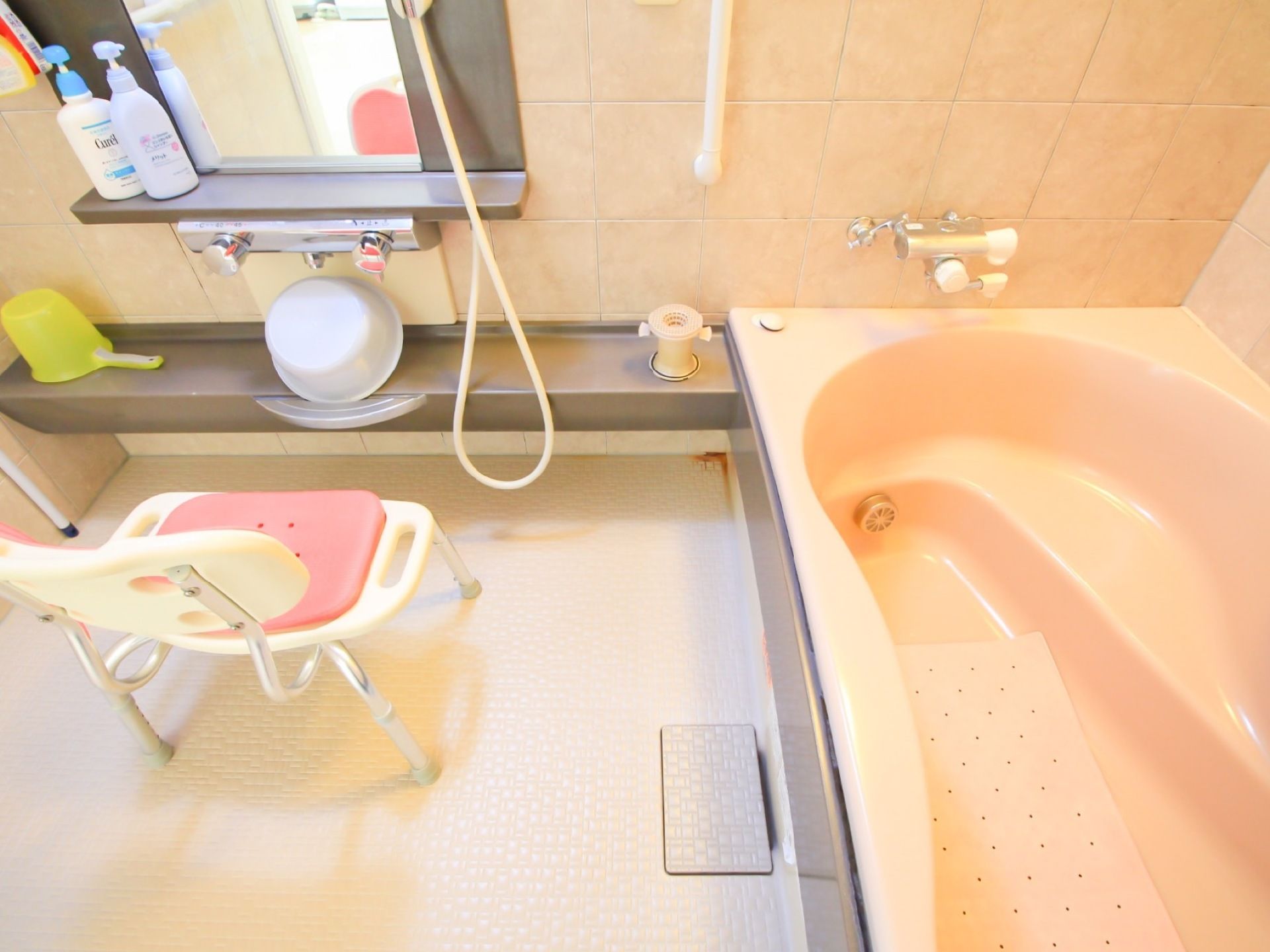 洗い場にはシャワーチェアや桶、シャンプーなどが用意されている。浴槽内には、滑り止めのマットが敷かれている。