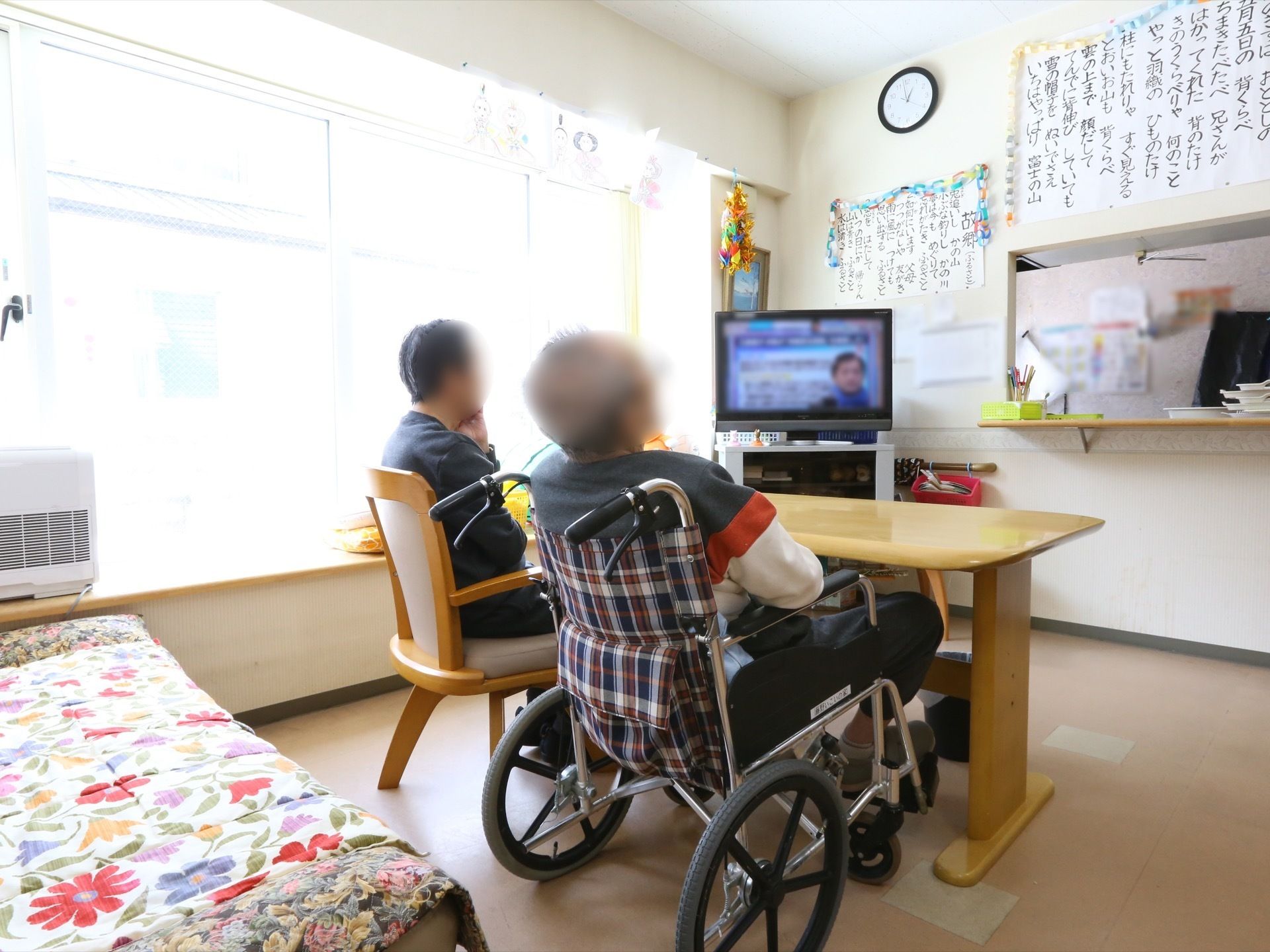 食堂には、対面式キッチンが併設されている。車椅子のまま席に着けるテーブルが用意されており、壁際にテレビが設置されている。