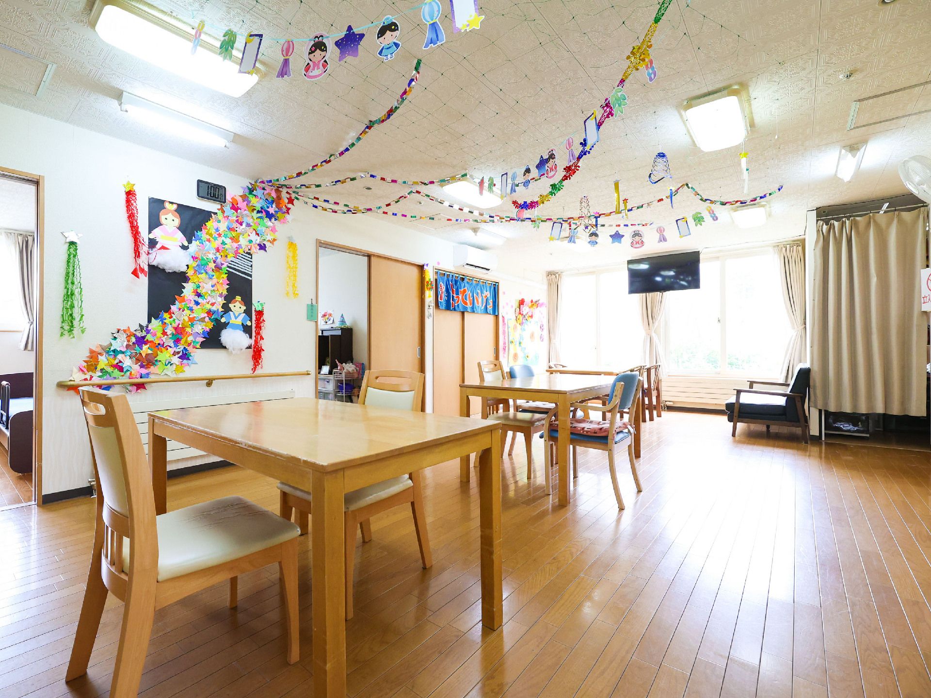 天井に飾りがつられているフローリングの部屋に置いてある四角の机