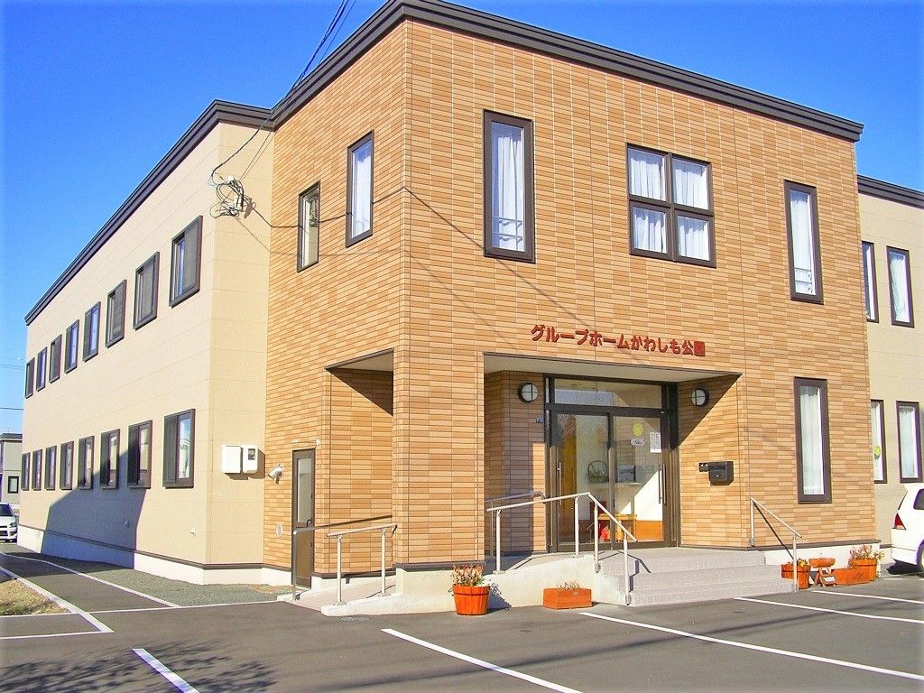 ベージュを基調にした清潔感のある施設外観。エントランスにスロープが付いている様子