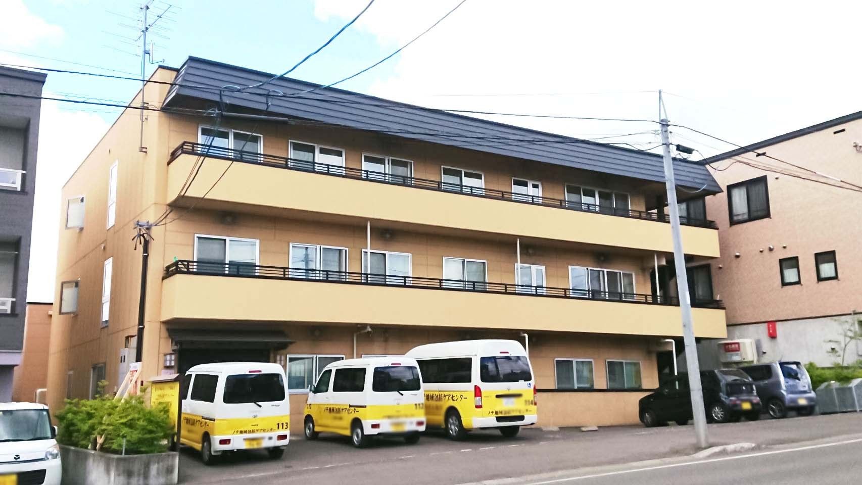黄色い建物と送迎車
