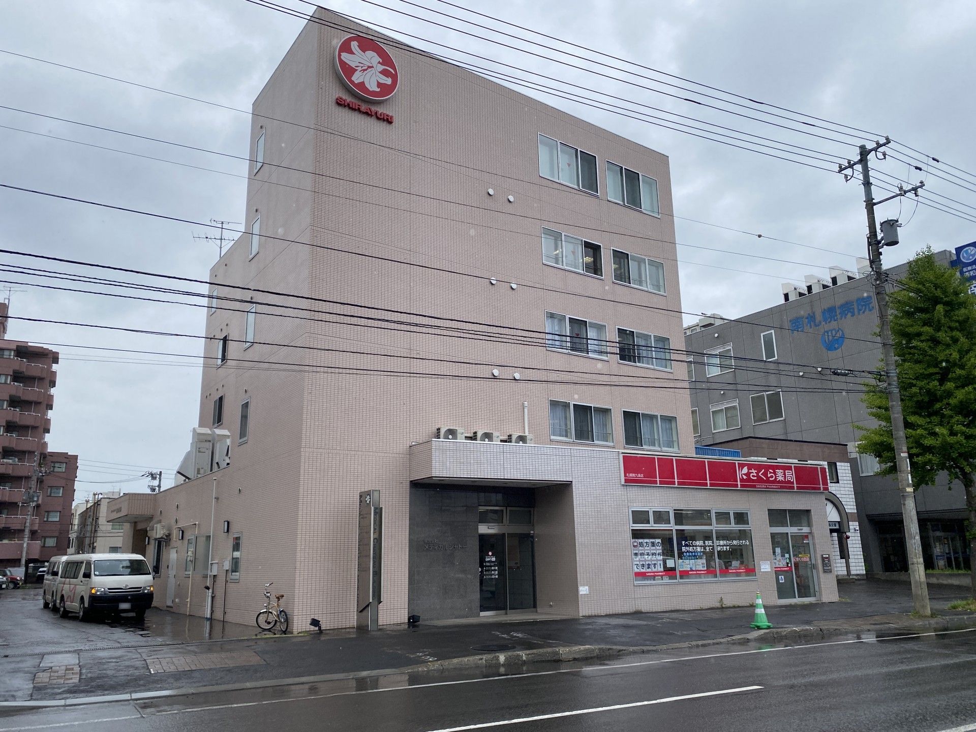 ブルーのエプロンを付けた若い女性スタッフに付き添われて屋外で笑顔で過ごしている車いすの高齢女性。