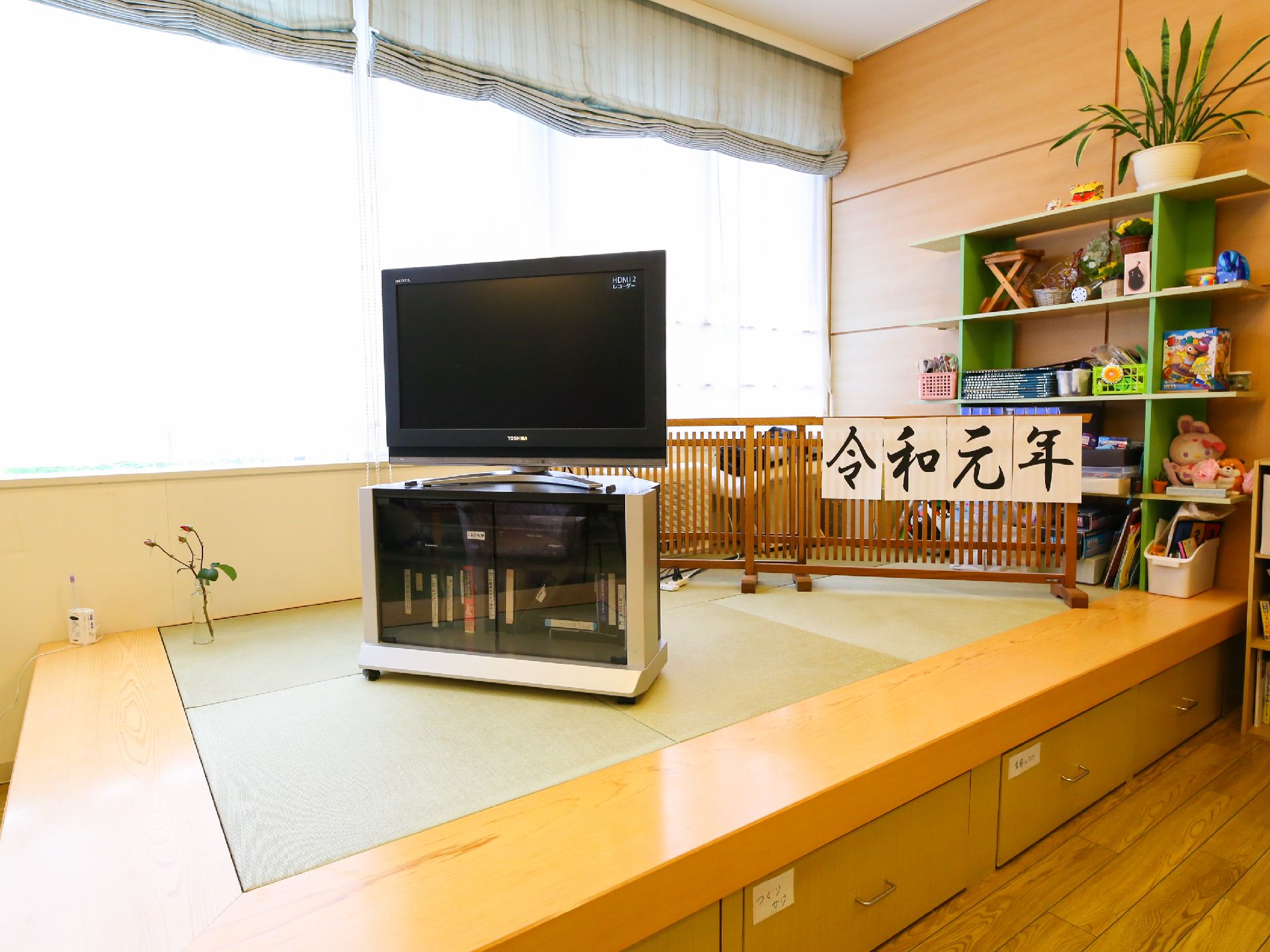 周囲から一段高くなった畳のスペースに置いてあるテレビ