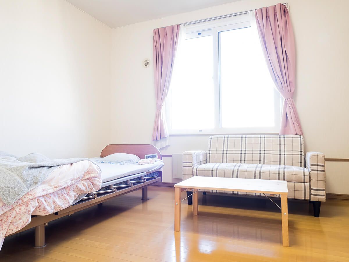 ソファやベッド、テーブルなどが置いてある窓があるワンルームタイプの部屋