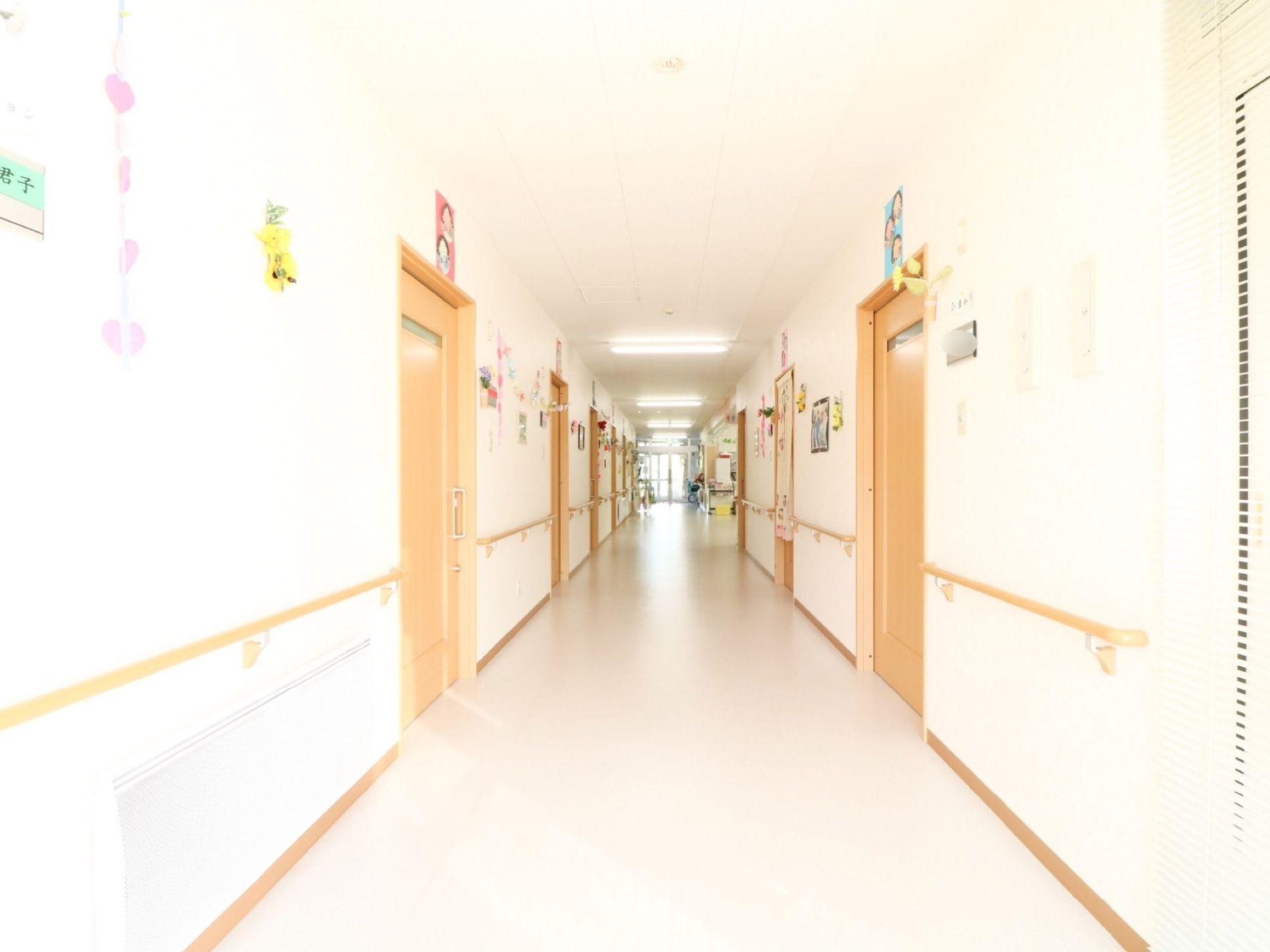 通路の両側に居室が並んでいる。居室の扉の上部には、部屋ごとに異なる人の顔を模した飾りが貼られている。
