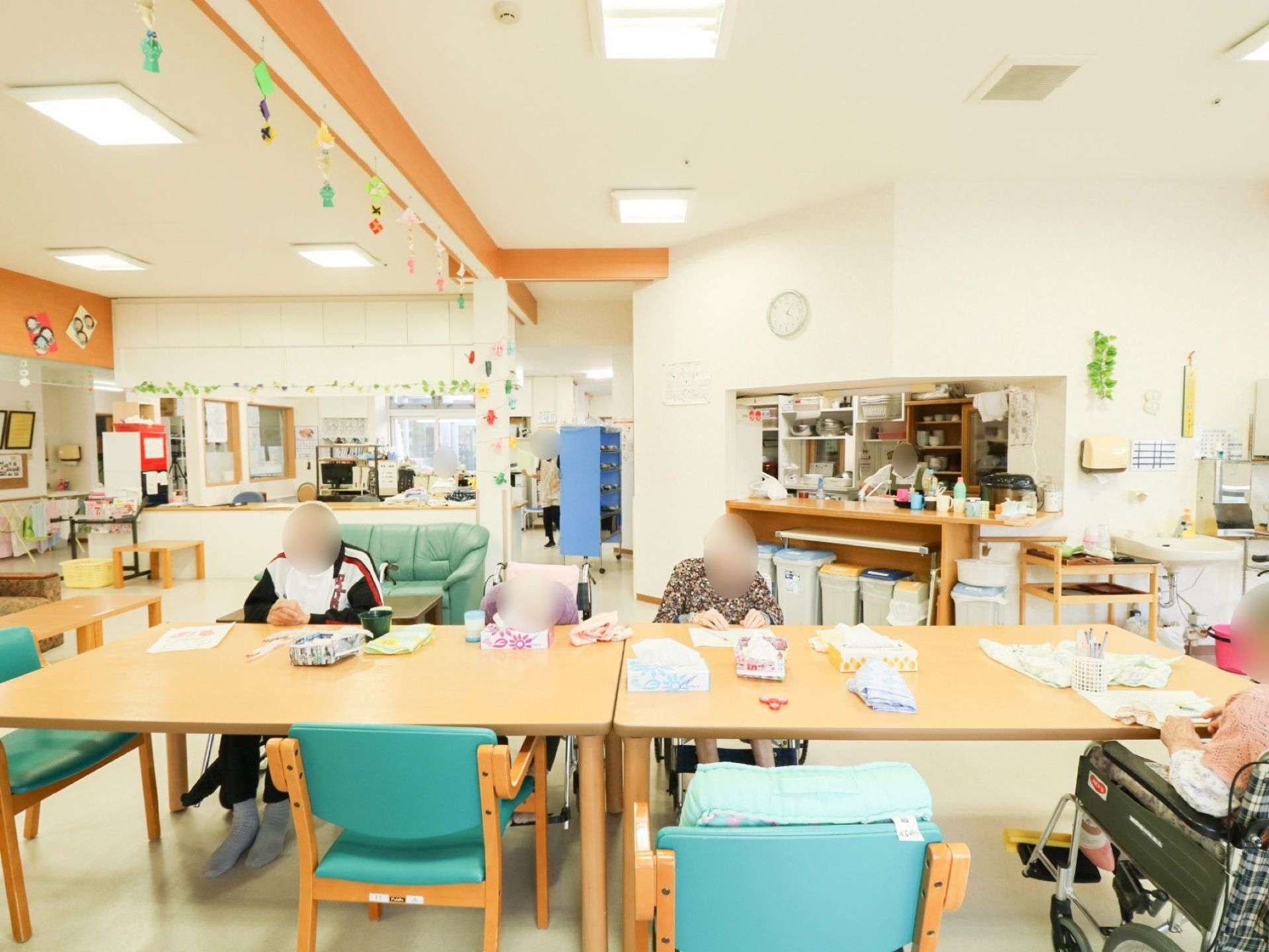 共有スペースにはオープンキッチンがあり、入居者様に温かいお食事を提供している。車椅子を使う方も着席しやすいよう配慮されている。