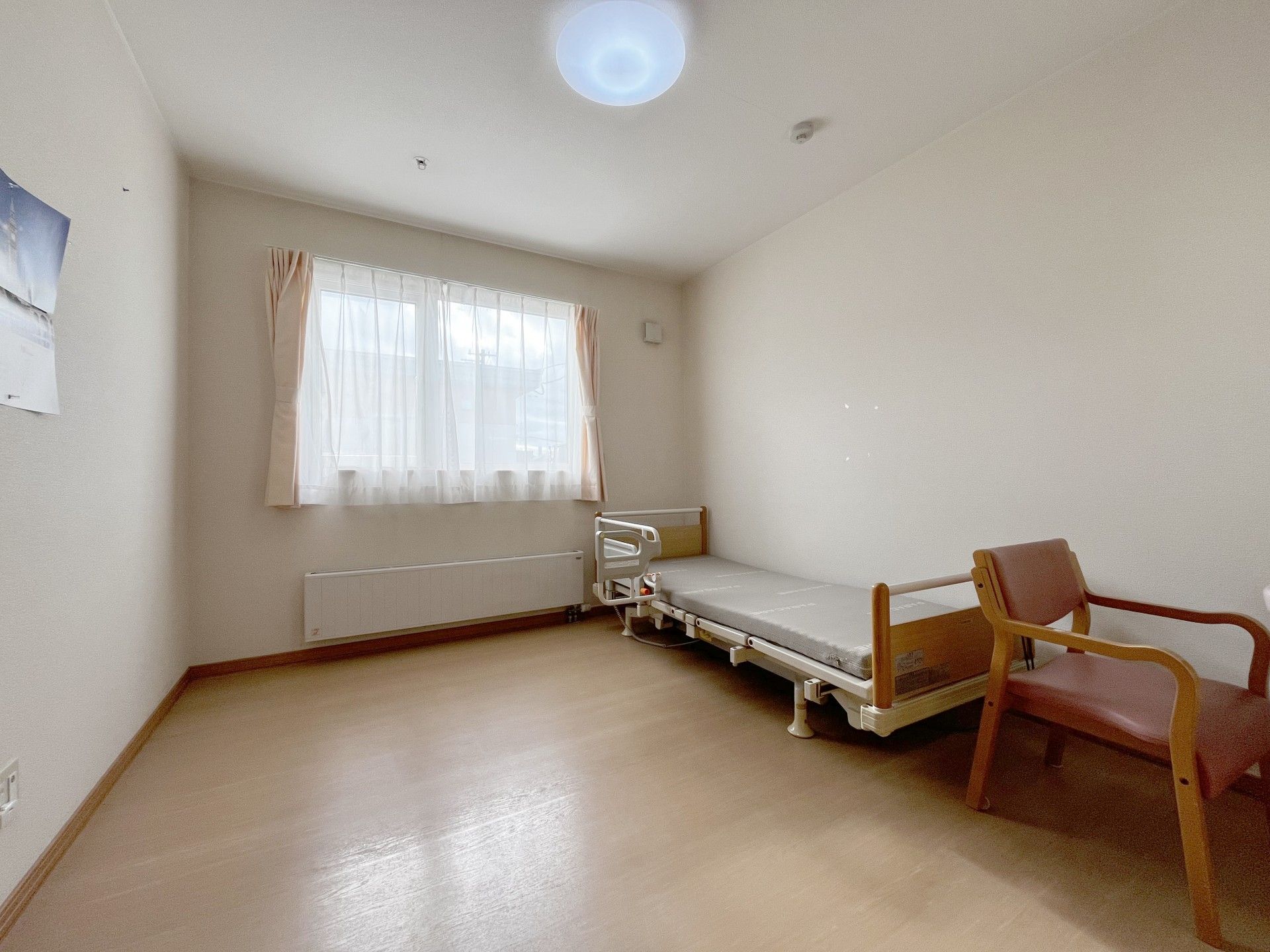 高齢者と一緒にカルテのようなものを眺めている施設内スタッフとの2ショット