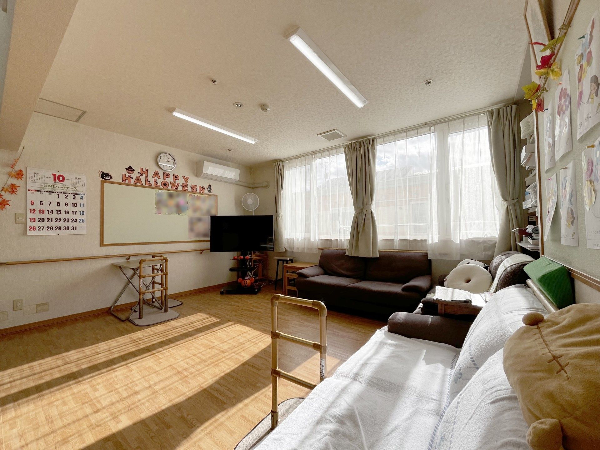 車いすにのる男性とそれを押している女性スタッフ。両側に自然が広がる遊歩道の写真