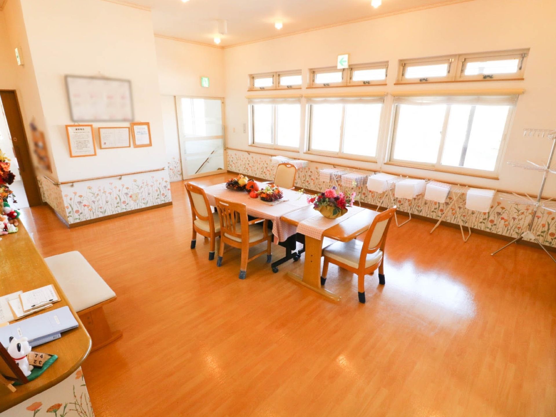 ラウンジは白い壁に、オレンジの花が足元だけ咲いたような華やかな内装となっている。中央にテーブルが置かれ、花などが飾られている。