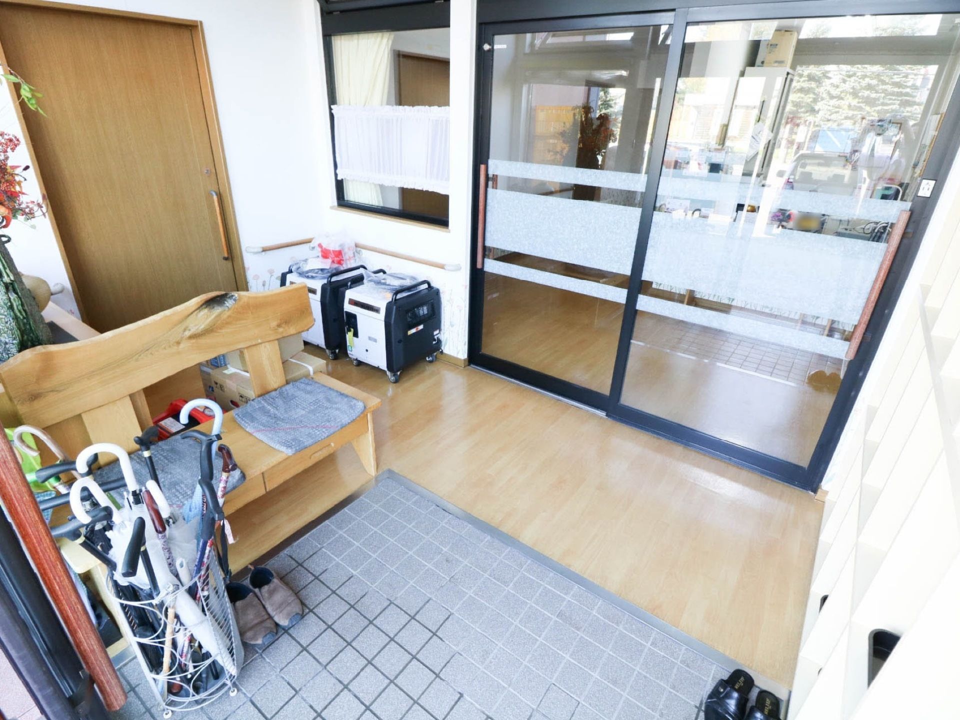 エントランスの風除室はバリアフリー対応で、段差がほとんどない。ベンチを設置して、安全に靴を履き替えられるようにしている。