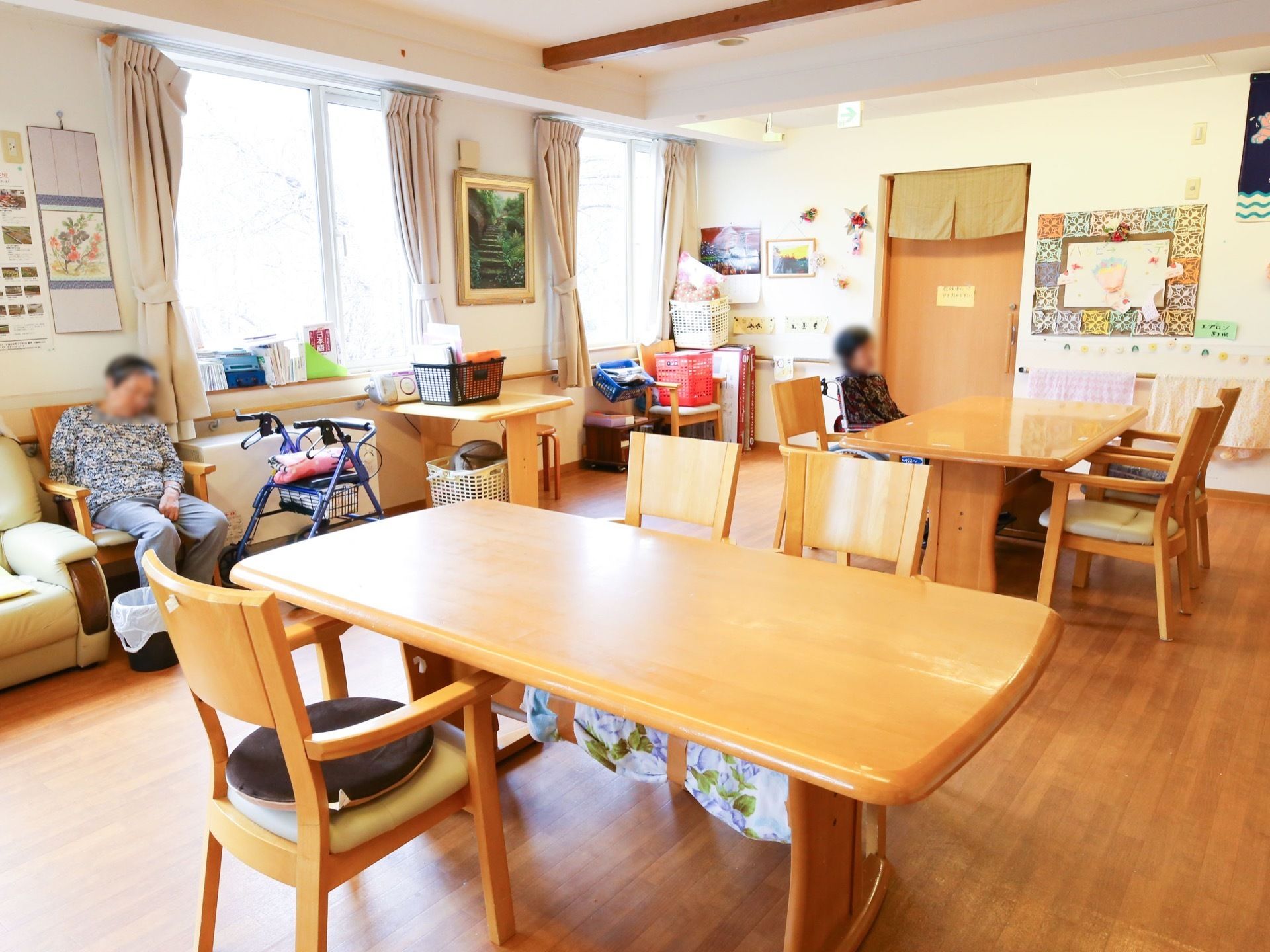 窓があるダイニングルームは、入居者様がリラックスできる場所となっている。４人がけテーブルの椅子は、肘掛けがついており座りやすい。
