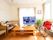 窓に囲まれた空間にテレビを置いている。テーブルの上には新聞が用意してある。新聞を読んだり、テレビを観たりして過ごすリビングルームである。