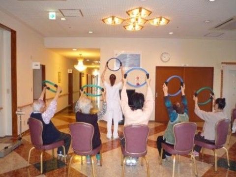 入居者がスタッフと一緒に、リングを使って体操をしている様子