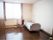 フローリング張りの部屋に、ベッドとピンク色の椅子、小さい机が置かれている