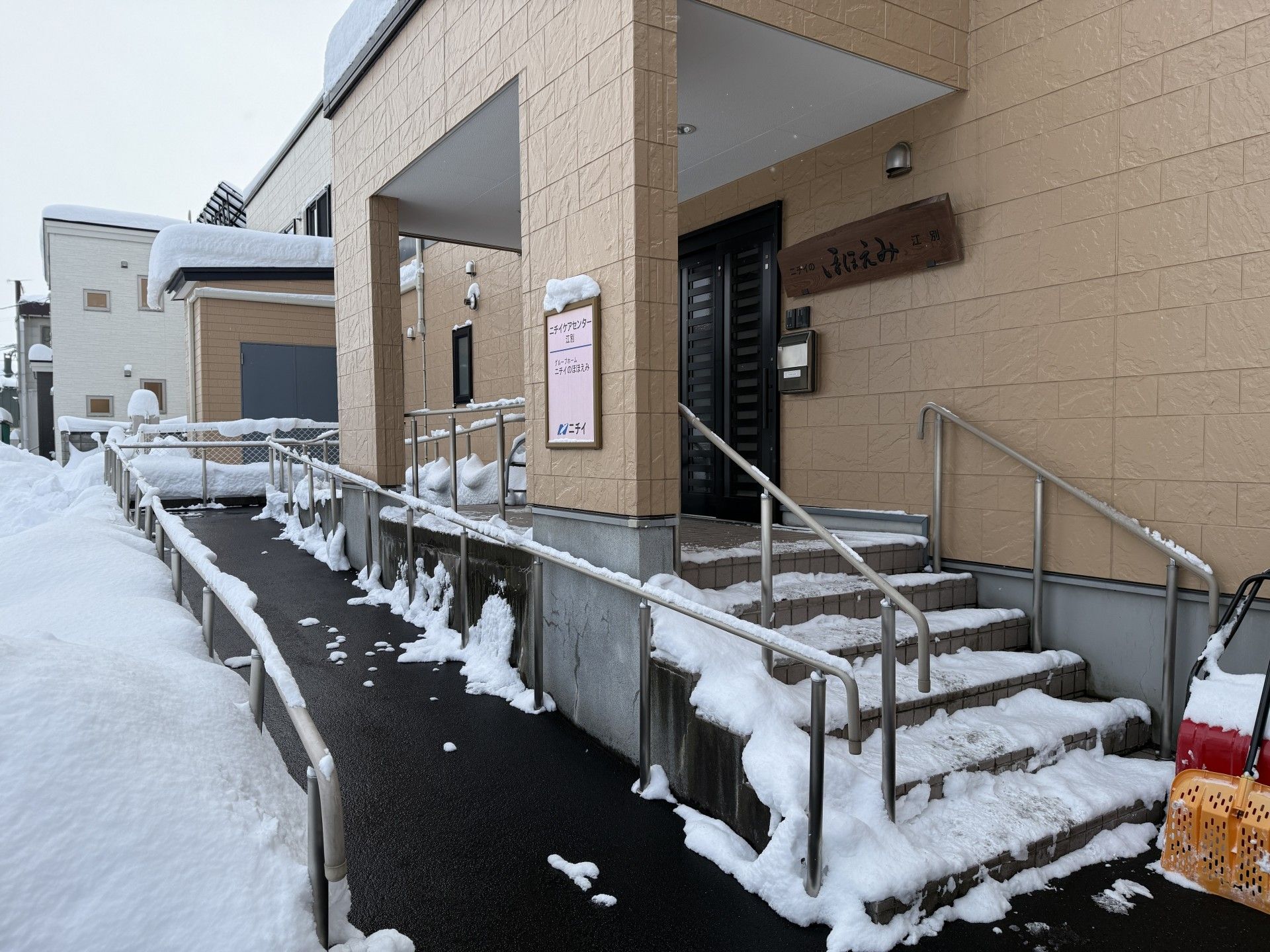 雪の中の玄関とスロープ