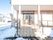 雪が積もっている。玄関から敷地面に下りる階段とその近くがきれいに雪かきされて、雪がない状態になっている。