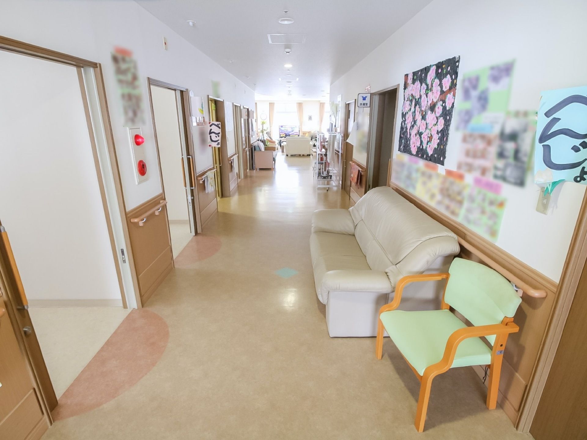 通路にはソファーがあり、壁には写真などを装飾した貼り紙などがたくさん貼ってある。生活感のあるアットホームな暮らしぶりがわかる。