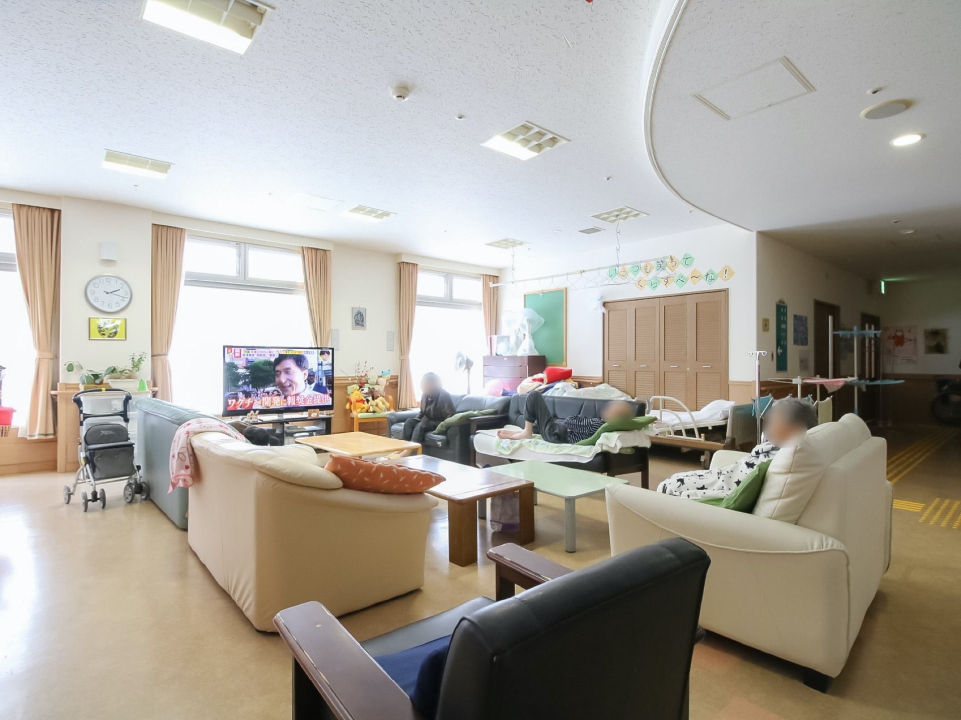 食堂には大きなテレビがあり、そのテレビを囲むようにソファーとテーブルが配置されている。入居者様が思い思いの場所でくつろいでいる。