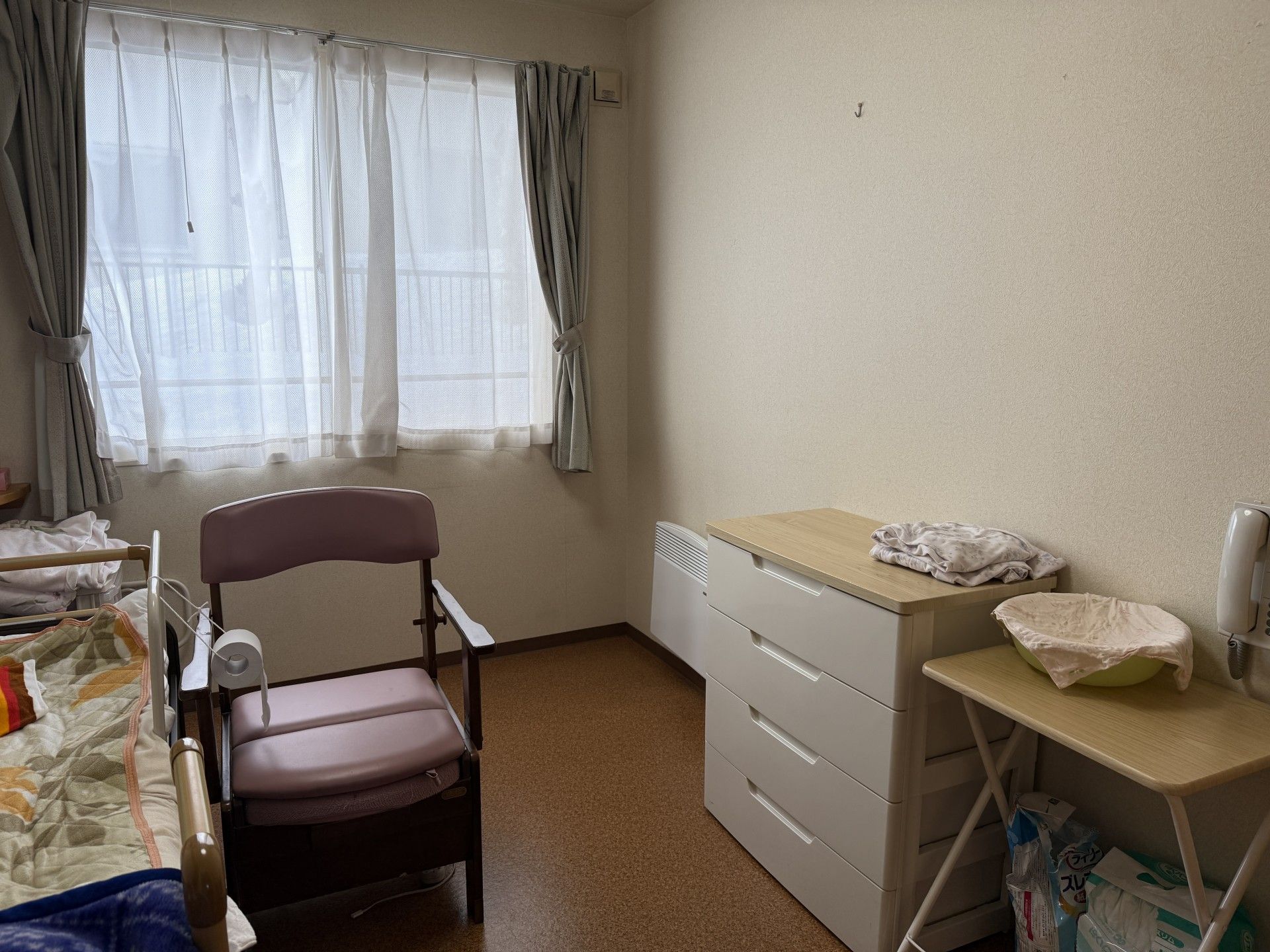 窓際のベッドと椅子の部屋