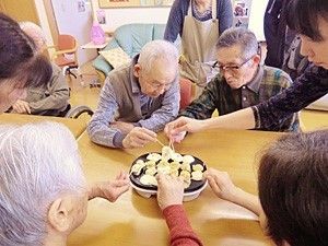 爪楊枝でたこ焼きを作っている入居者の様子。