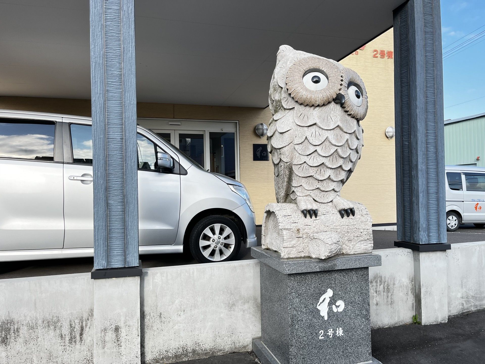フクロウの石像と車