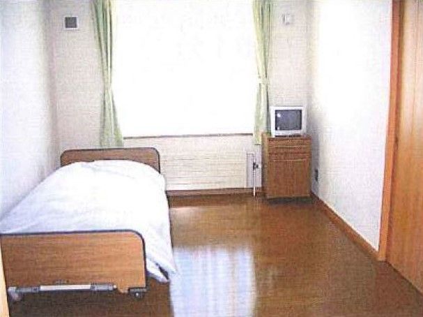一人用のベッドやテレビ、日が差し込む窓がある人利用のワンルーム。広めの居室の様子
